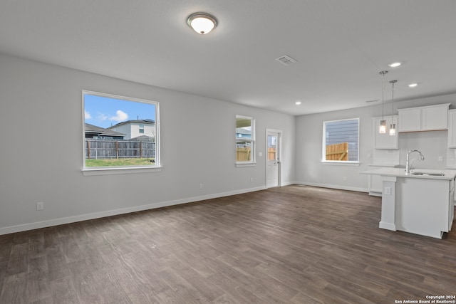 unfurnished living room featuring dark wood-type flooring and sink