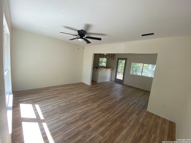 unfurnished living room with ceiling fan and dark hardwood / wood-style flooring