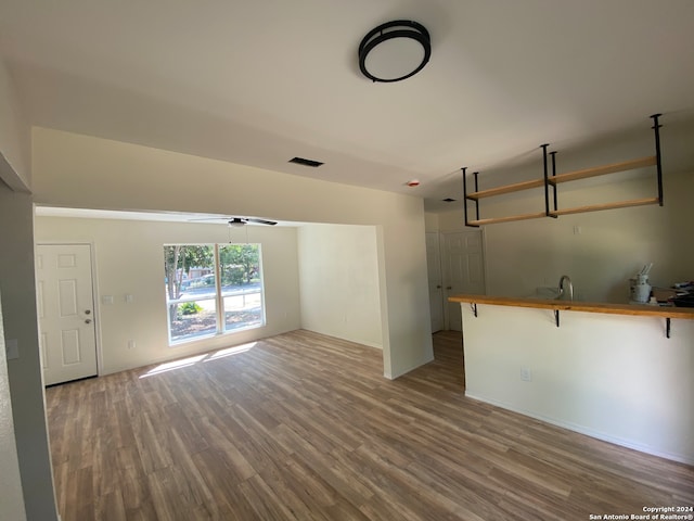 unfurnished living room with wood-type flooring and ceiling fan