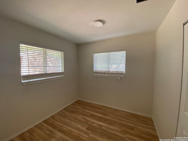 spare room with plenty of natural light and hardwood / wood-style floors