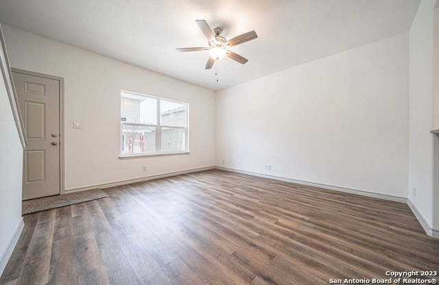 unfurnished room with dark wood-type flooring and ceiling fan