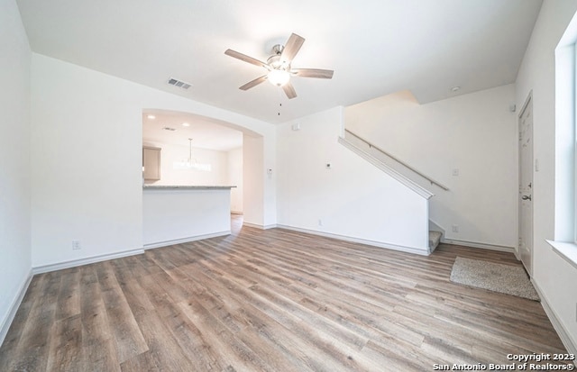 unfurnished living room featuring ceiling fan and hardwood / wood-style floors