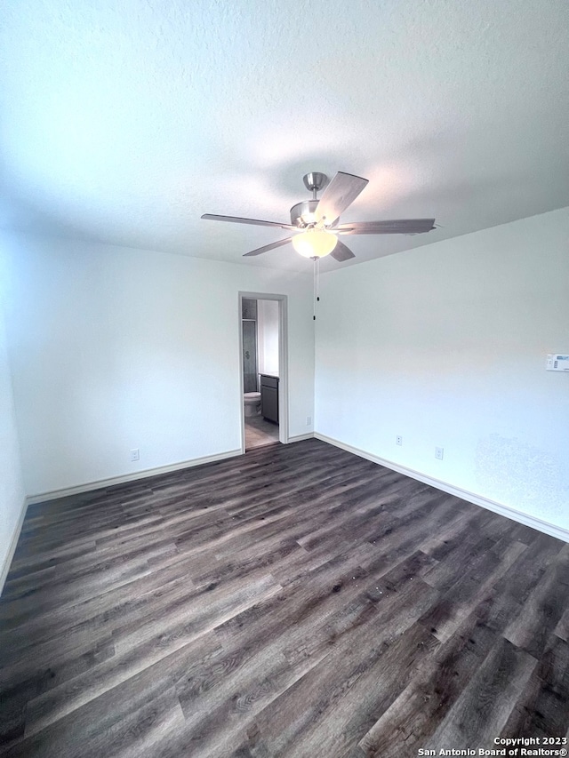 empty room with ceiling fan, a textured ceiling, and dark hardwood / wood-style flooring