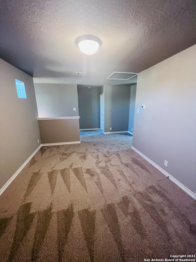 unfurnished room featuring carpet floors and a textured ceiling