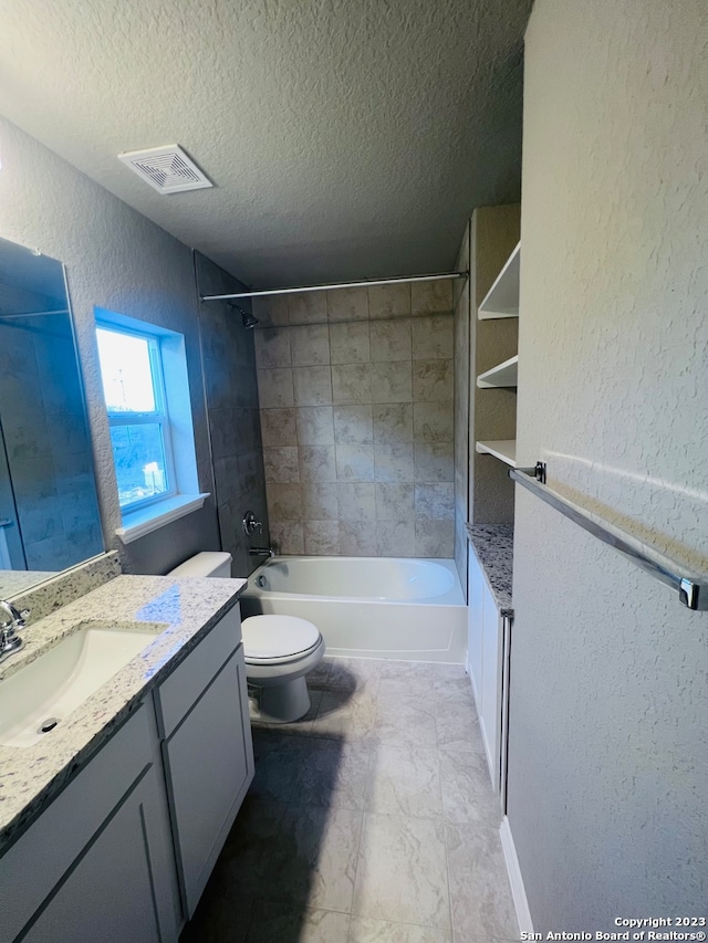 full bathroom featuring vanity, tiled shower / bath combo, a textured ceiling, and toilet