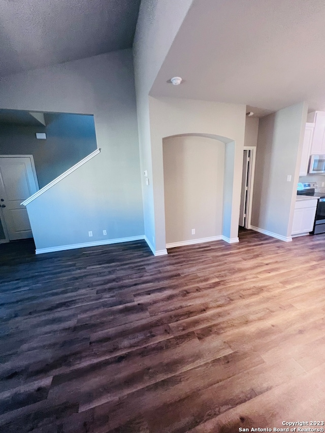 unfurnished living room with a textured ceiling and dark hardwood / wood-style flooring