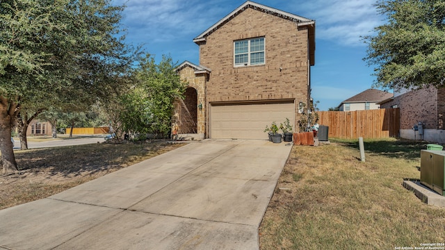 view of property featuring a garage and a front lawn