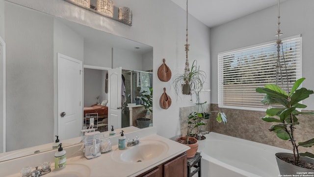 bathroom featuring plus walk in shower, vanity, and a wealth of natural light