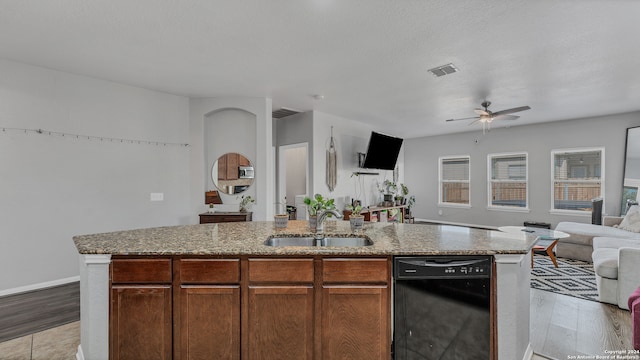 kitchen with an island with sink, light wood-type flooring, ceiling fan, sink, and dishwasher