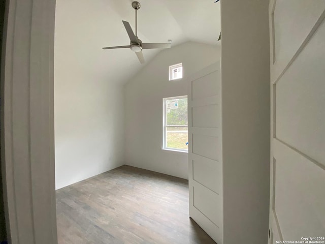 empty room featuring light hardwood / wood-style floors, vaulted ceiling, and ceiling fan