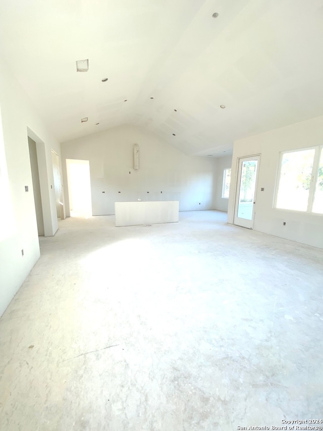 unfurnished living room featuring vaulted ceiling