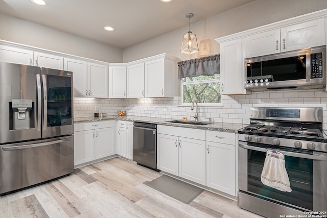 kitchen with appliances with stainless steel finishes, light stone countertops, and white cabinets