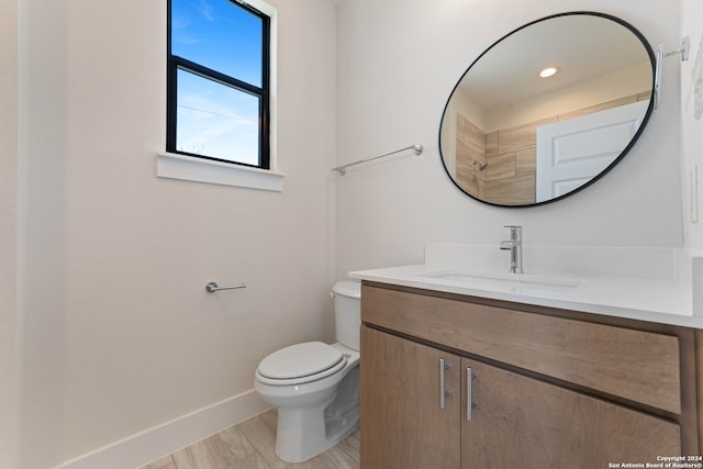 bathroom with hardwood / wood-style flooring, vanity, and toilet