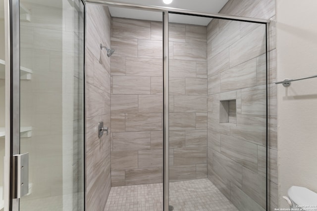 bathroom with toilet and an enclosed shower