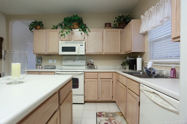 kitchen featuring white appliances, light tile patterned flooring, light brown cabinets, and sink