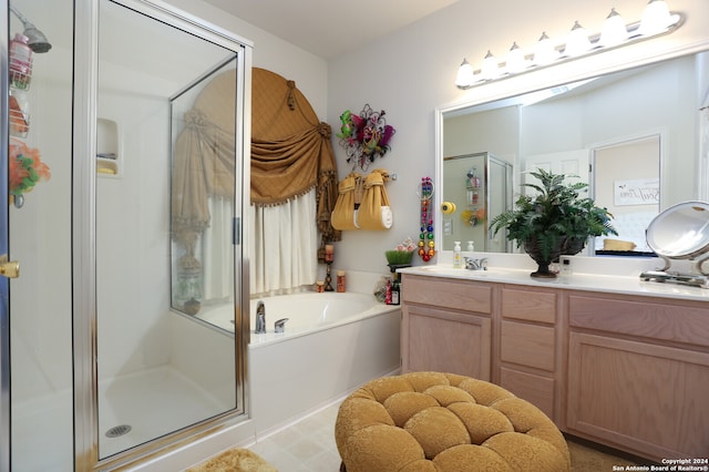 bathroom featuring vanity and independent shower and bath