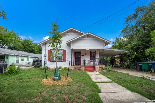 bungalow-style home featuring a front yard, a porch, and a carport