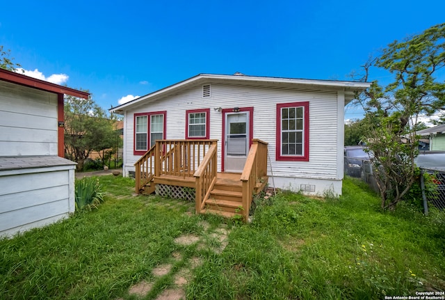 rear view of property featuring a lawn