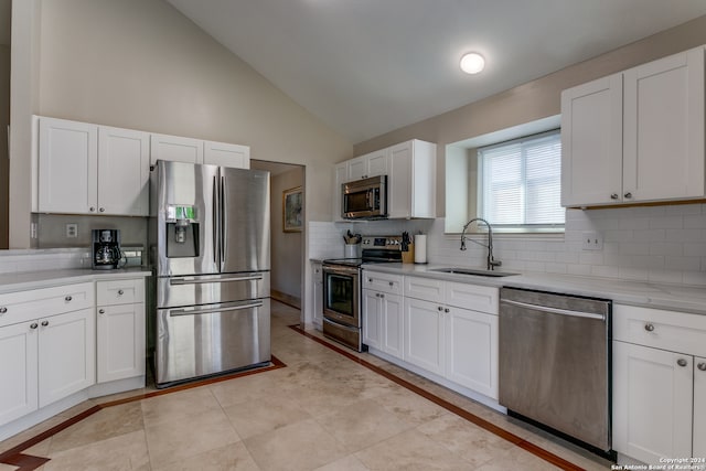 kitchen with high vaulted ceiling, decorative backsplash, stainless steel appliances, white cabinets, and sink