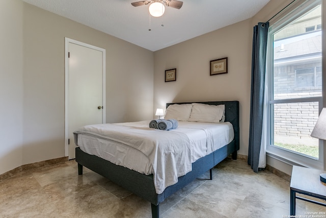 bedroom with ceiling fan and a textured ceiling