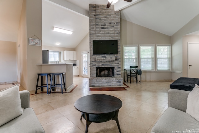 tiled living room with a fireplace, high vaulted ceiling, beamed ceiling, and ceiling fan