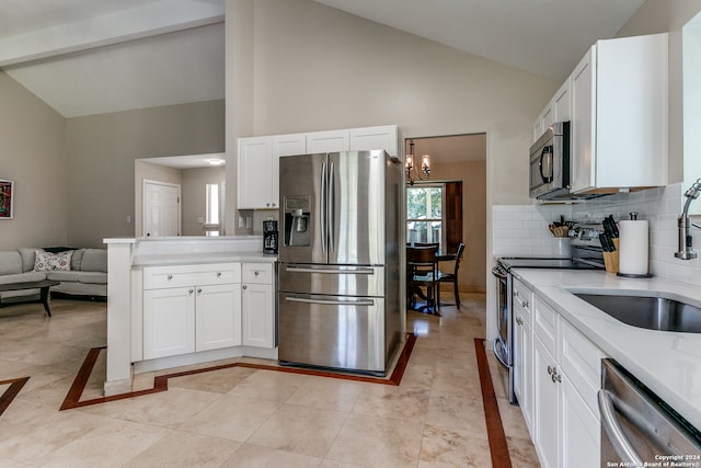 kitchen with appliances with stainless steel finishes, light stone counters, sink, and white cabinets