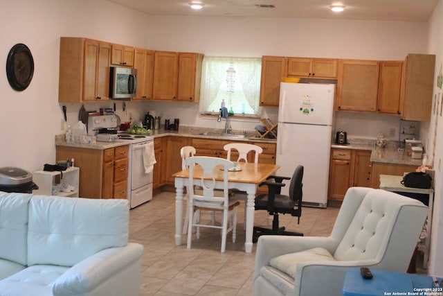 kitchen with white appliances, sink, and light tile patterned floors