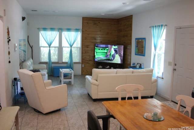 tiled living room with wooden walls and a healthy amount of sunlight