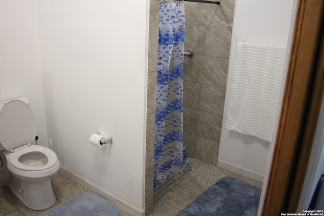 bathroom with tile patterned flooring, toilet, and a shower with curtain