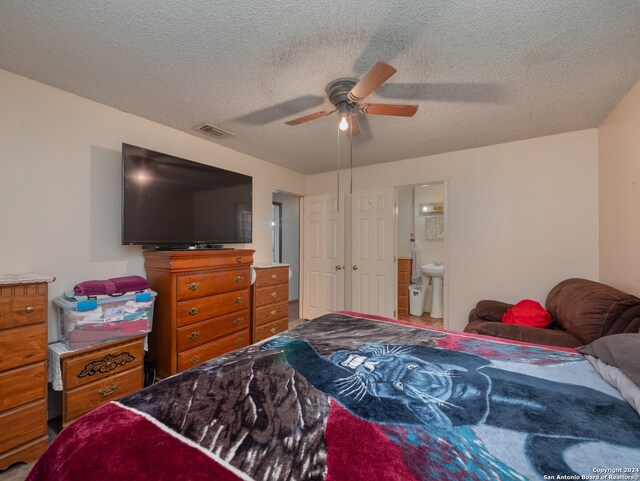 bedroom featuring ensuite bath, a textured ceiling, and ceiling fan