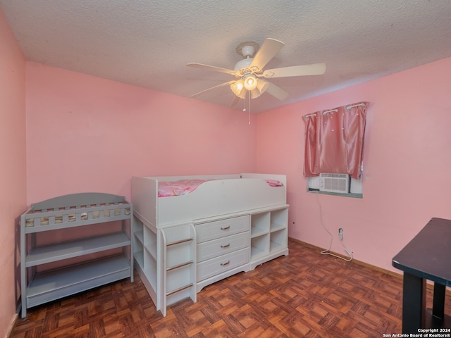 bedroom featuring ceiling fan, a textured ceiling, and dark parquet floors