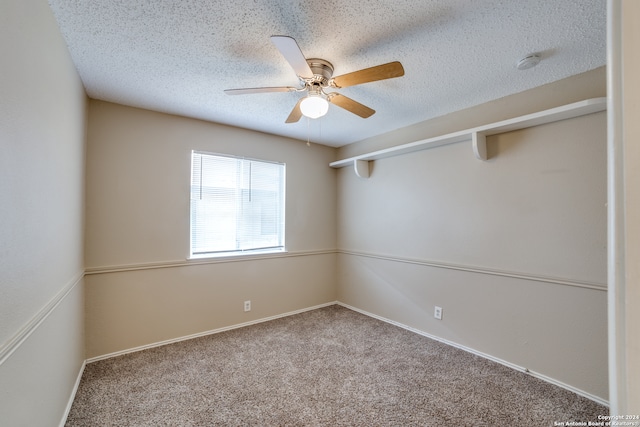 carpeted spare room featuring ceiling fan and a textured ceiling