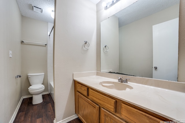 full bathroom featuring vanity, wood-type flooring, a textured ceiling, bathing tub / shower combination, and toilet