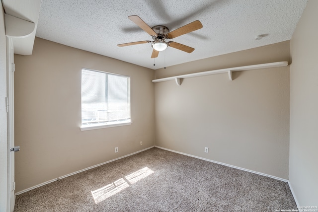 empty room featuring ceiling fan, carpet, and a textured ceiling