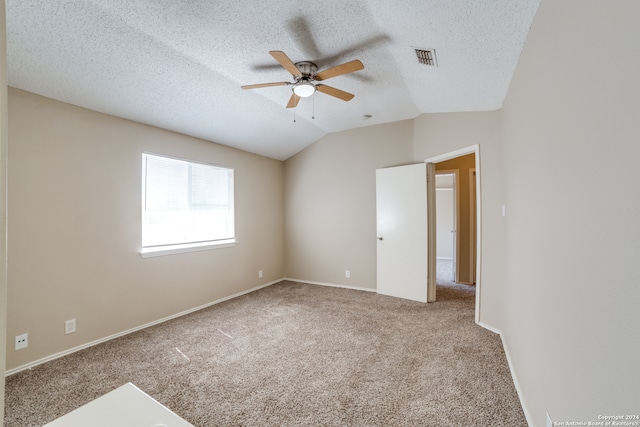 carpeted empty room with ceiling fan, a textured ceiling, and vaulted ceiling