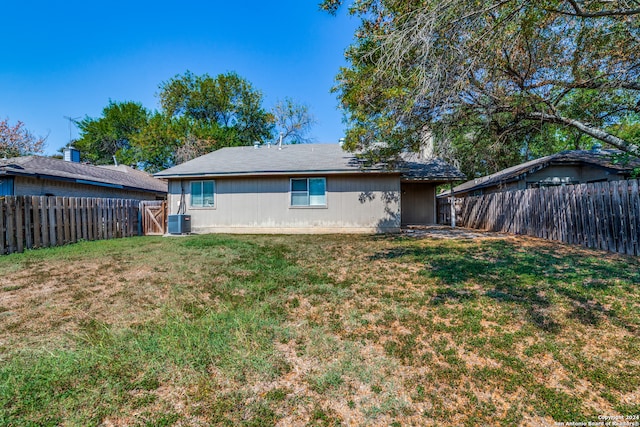 back of property featuring central AC and a lawn