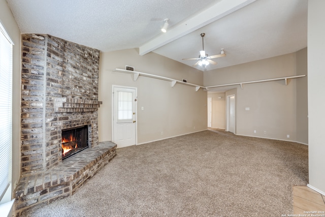 unfurnished living room featuring carpet floors, vaulted ceiling with beams, a fireplace, and ceiling fan