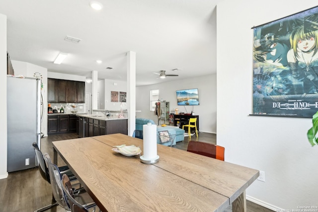 dining room featuring ceiling fan, sink, and dark hardwood / wood-style flooring