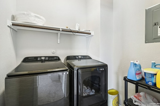 clothes washing area featuring electric panel and washer and dryer