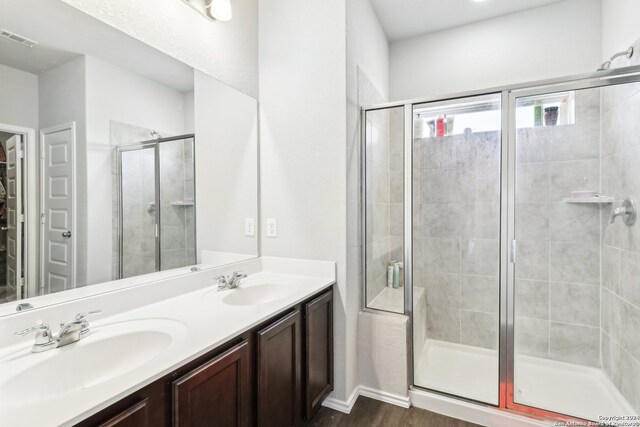 bathroom featuring hardwood / wood-style flooring, vanity, and walk in shower