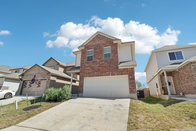 front of property with a front lawn, cooling unit, and a garage