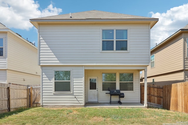 rear view of house featuring a lawn and a patio area