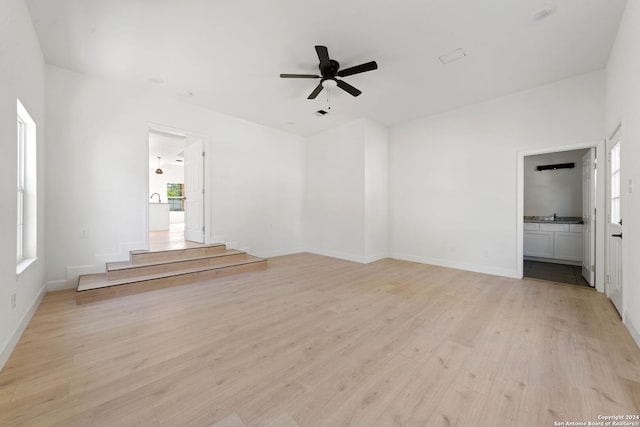 unfurnished living room featuring ceiling fan and light wood-type flooring