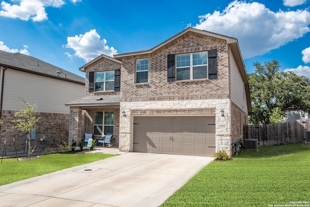 view of front of home featuring central AC unit, a garage, and a front lawn