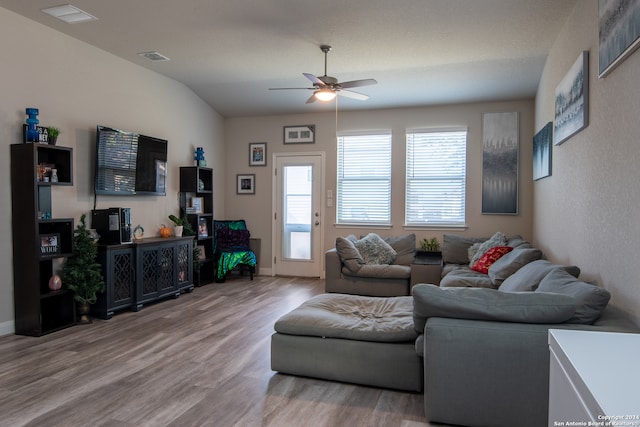 living room with lofted ceiling, light hardwood / wood-style floors, and ceiling fan