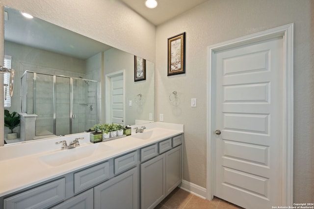 232 Wickersham, Boerne, TX 78015 - bathroom with double vanity, baseboards, tile patterned floors, a sink, and a stall shower