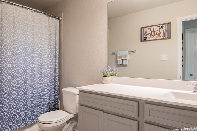 bathroom with toilet, walk in shower, and vanity