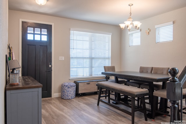 dining area featuring light wood-type flooring, an inviting chandelier, and a wealth of natural light