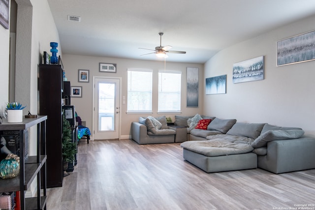 living room featuring ceiling fan, light hardwood / wood-style flooring, and vaulted ceiling