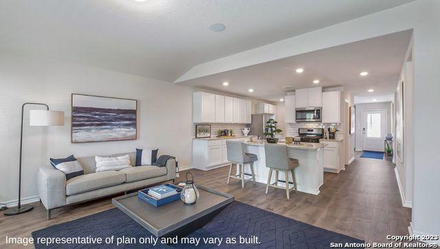 living area featuring baseboards, recessed lighting, and dark wood finished floors